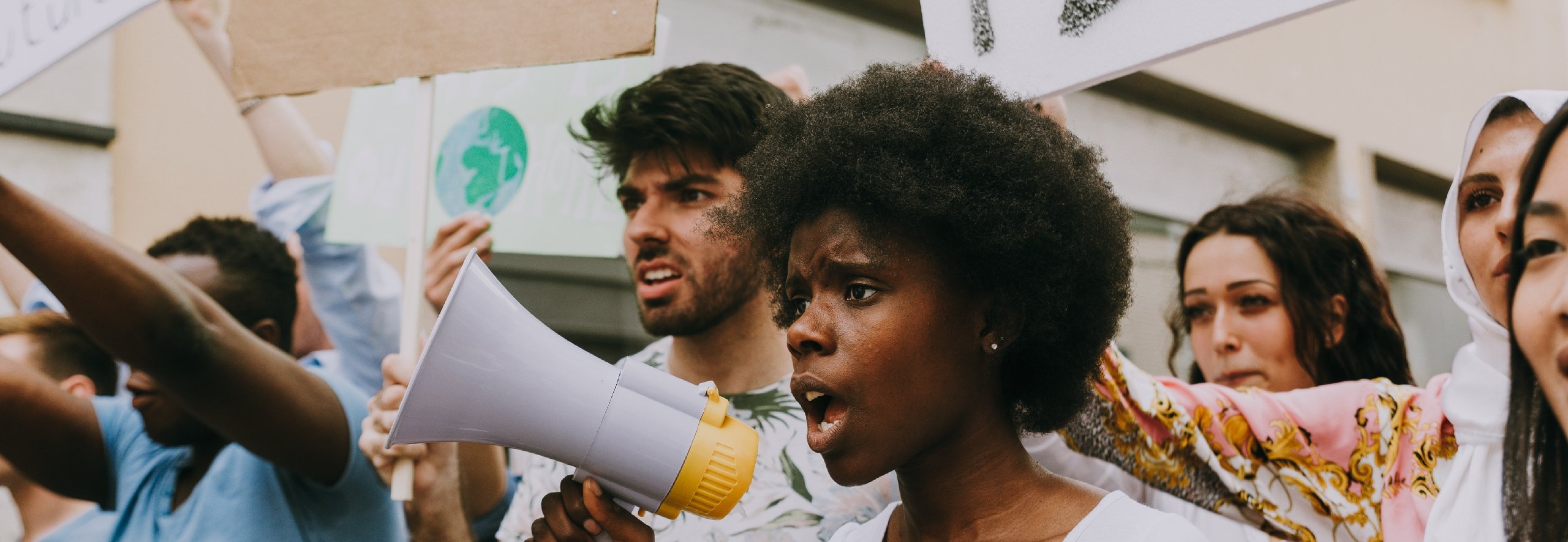 Diverse group of protestors holding megaphone and signs