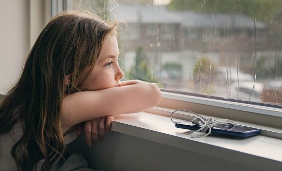 girl watching the world from a window