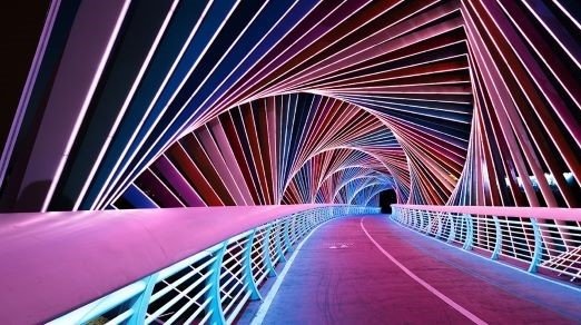 futuristic looking bridge at night with lights