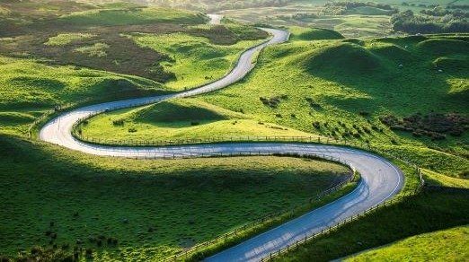 image of winding road in green rolling hills