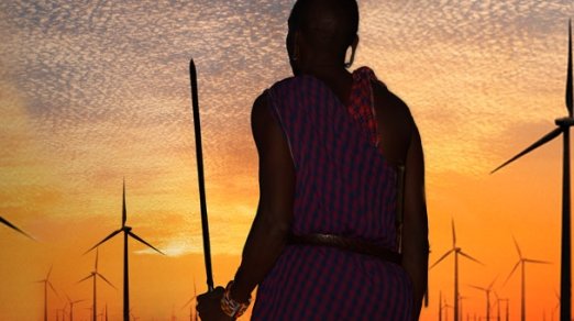 Maasai warrior standing amid power windmills