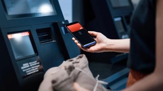 person holding a cell phone at a POS terminal